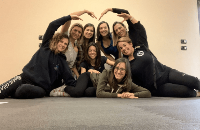 Gruppo di partecipanti ai corsi in presenza del Metodo Ipopressivo Multidisciplinare che forma un cuore con Mimi di Ipopressivi Italia